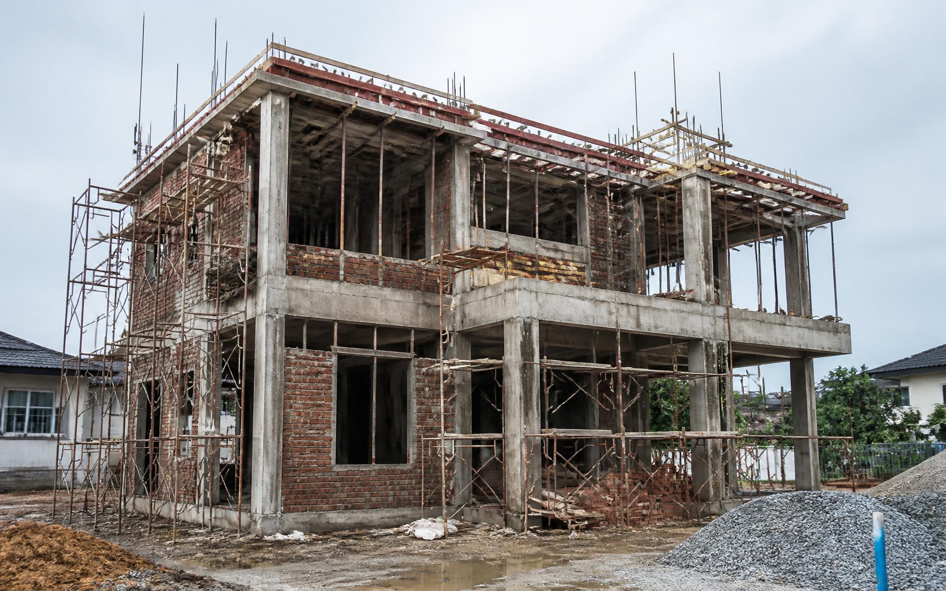 Two storey house under construction with reinforced concrete frame and brickwork